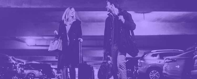 two people walking in a airport parking garage with suitcases in purple overlay