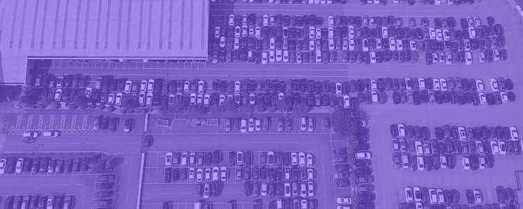 very big parking lot with several parked cars in a purple overlay